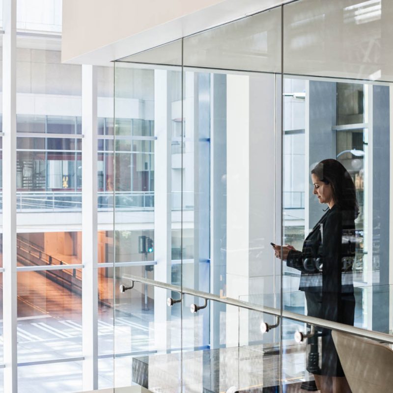 Businesswoman standing in a conference room window in a large business center.