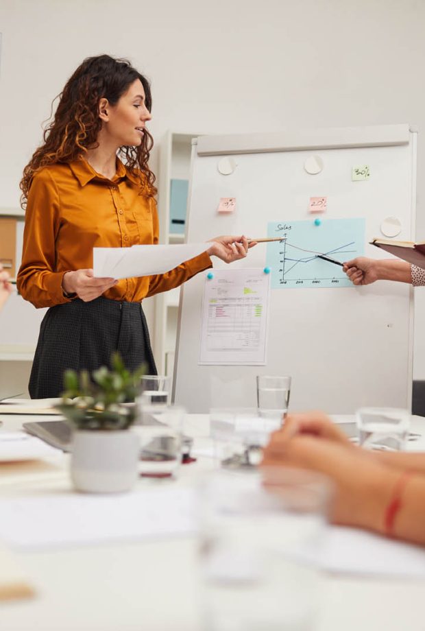 Two beautiful business colleagues working together at meeting making report, horizontal point of view shot